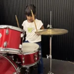 A girl learning drums