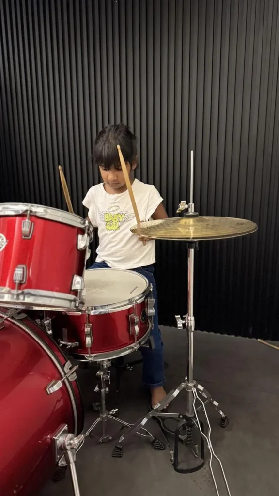 A girl learning drums